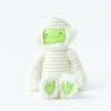 A glow-in-the-dark Slumberkins Halloween Gift Set - Mummy Kin plush toy, with white fabric wrappings and lime green accents on the feet and face, sitting against a white background.