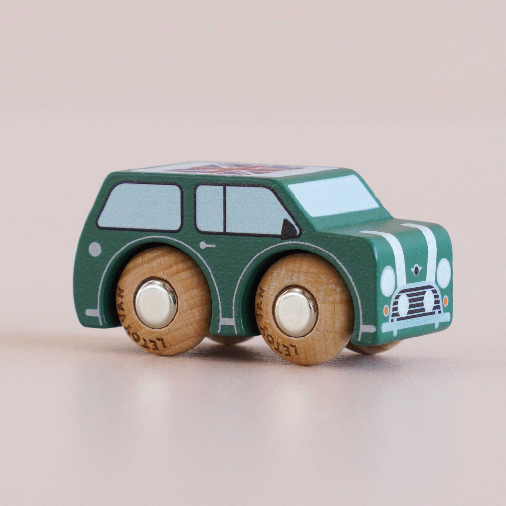 The No. 7 GT45 Molly, a small green wooden car with white stripes and round wooden wheels, is displayed on a light background, capturing the charm of a classic British toy. Made in England.