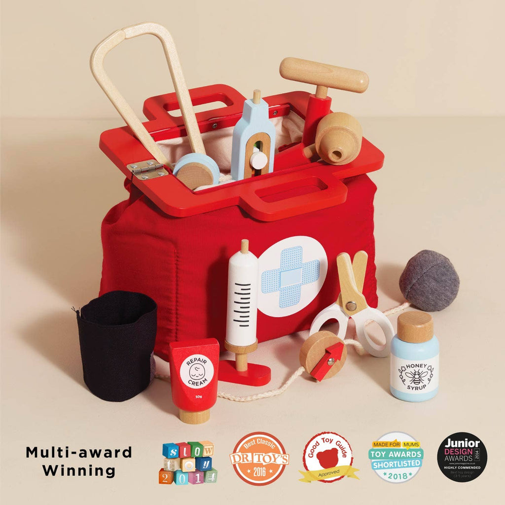 The Pretend Play Vintage Doctor Set is a red kids’ medical bag with a white cross, filled with wooden tools like a stethoscope, syringe, scissors, and medicine bottles. “Multi-award Winning” badges appear below the bag.