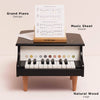 The Wooden Grand Piano Toy is a small black piano with labeled keys, a music sheet stand holding sheet music, and natural FSC-certified wood legs. Features include "Grand Piano Design," "Music Sheet Stand," and "Natural Wood Legs.