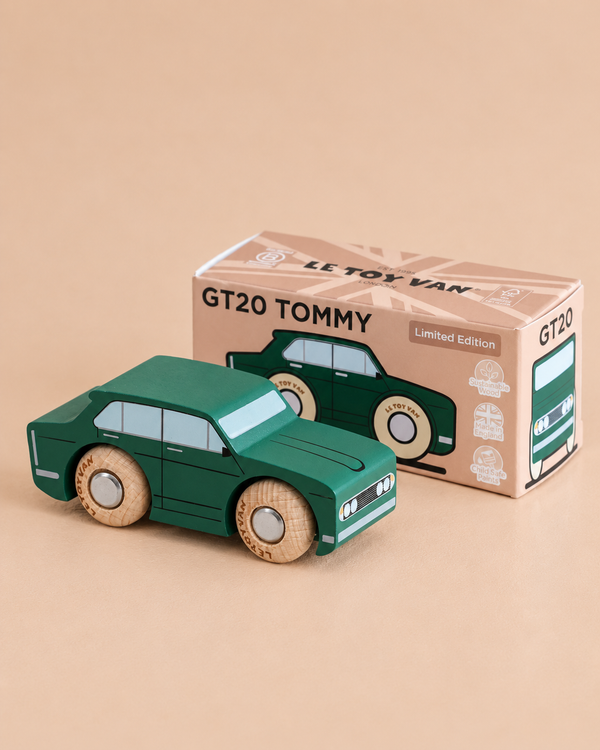 A green wooden toy car is positioned in front of its box, which is labeled “No. 3 GT20 Tommy | Made in England” and “Le Toy Van Limited Edition.” This charming retro toy evokes the feel of a nostalgic collectible, set against a solid beige background.