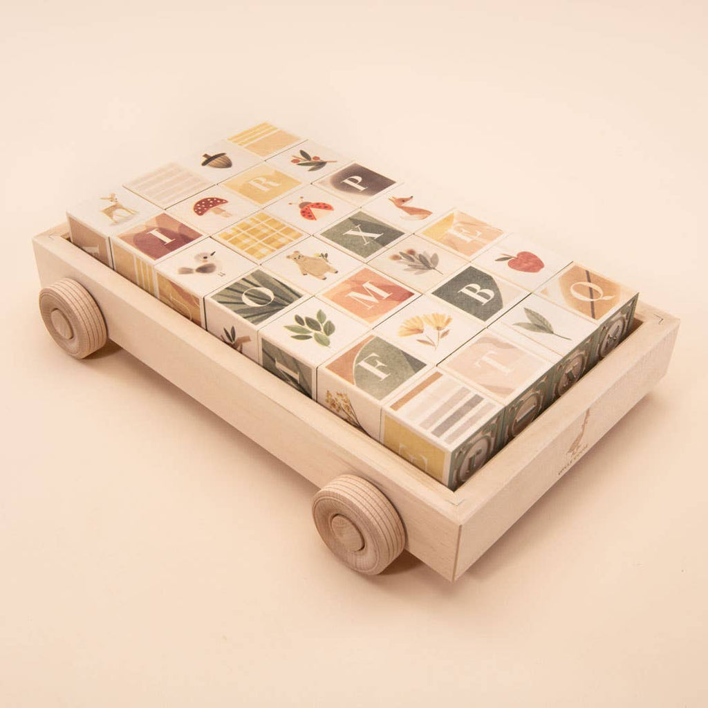 The Uncle Goose Watercolor ABC Blocks with Wagon features a wooden cart with four wheels, holding vibrant alphabet blocks decorated with uppercase letters and nature-inspired watercolor illustrations—ideal for early learning and play.