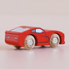 The No. 18 GT100 Jasper, handmade in England from sustainable wood, sits atop a pale pink surface. This small red wooden sports car features wooden wheels, simple cartoon-inspired details, and black-painted windows and doors—a playful nod to classic performance motoring.