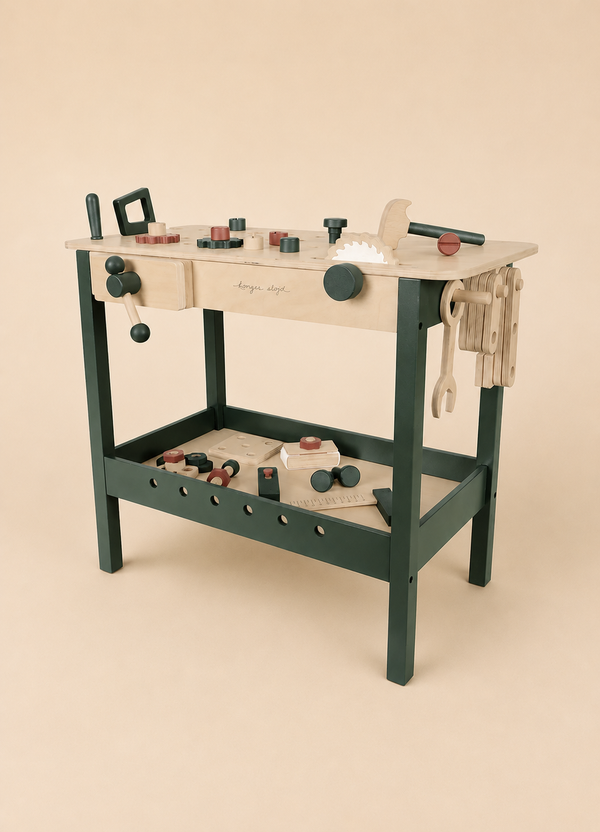 The Konges Sloejd Tool Bench is a charming wooden toy workbench featuring realistic tools and accessories—including a saw, hammer, wrench, and bolts—crafted in natural wood and dark green hues. Set against a beige background, this kids workbench is perfect for inspiring imaginative play with authentic wooden tools.