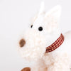 Pull-Along Lola, a plush white dog with curly fur, black button eyes, a brown nose, and a red-and-yellow plaid collar, makes an adorable toddler gift. Pictured against a plain white background.