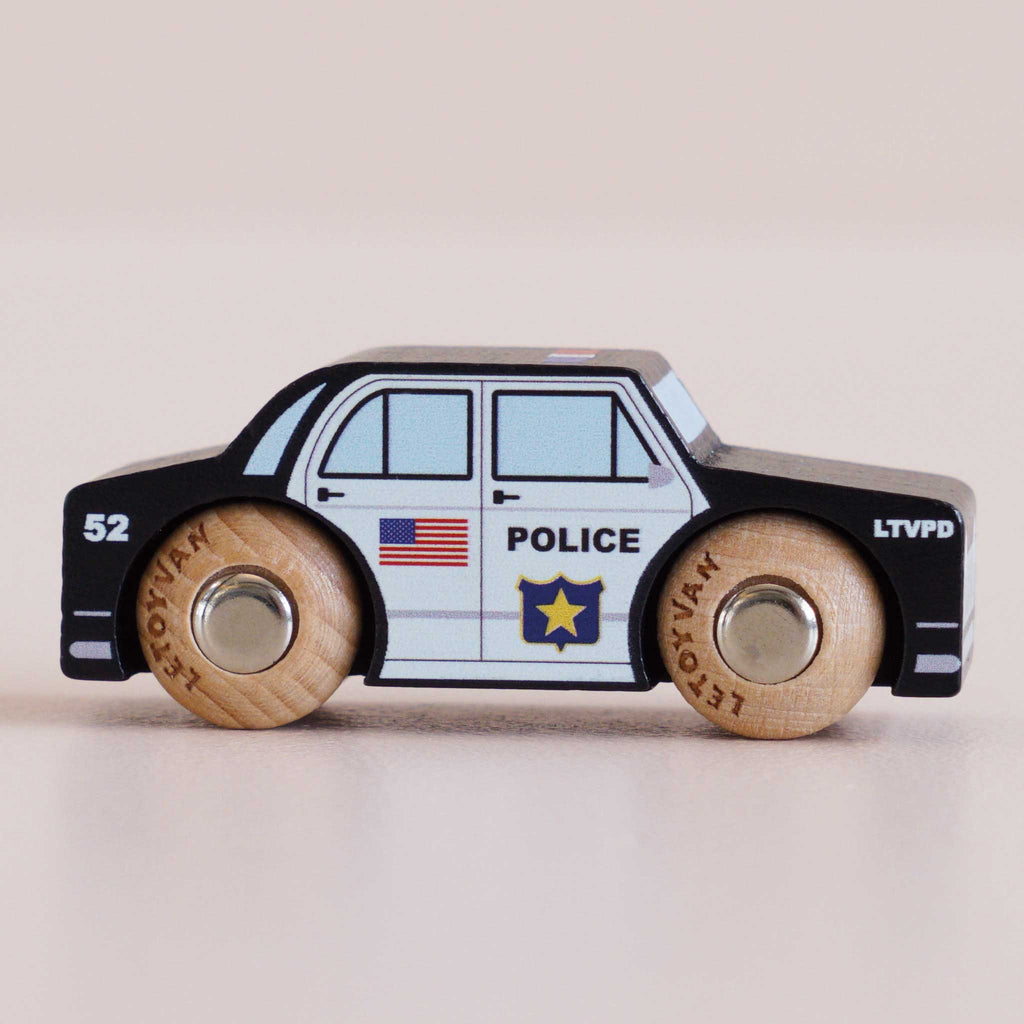 Introducing the No. 41 GT255 Sam, a classic wooden police car made in England. This charming toy features a bold black and white design, realistic police emblem, American flag, and the number 41 on its side. Ideal for imaginative play, its natural wooden wheels are stamped with “LE TOY VAN,” adding to its timeless appeal.