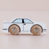 The No. 21 GT120 William, a white wooden racing car with simple black outlines and natural wood wheels, made in England and reminiscent of a retro toy car, is photographed on a light background.