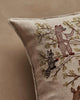 Close-up of the Coral & Tusk Woodland Living Tree Pillow, featuring embroidered forest animals like a raccoon with a red item and a bear among green leafy branches. Ships in one week.
