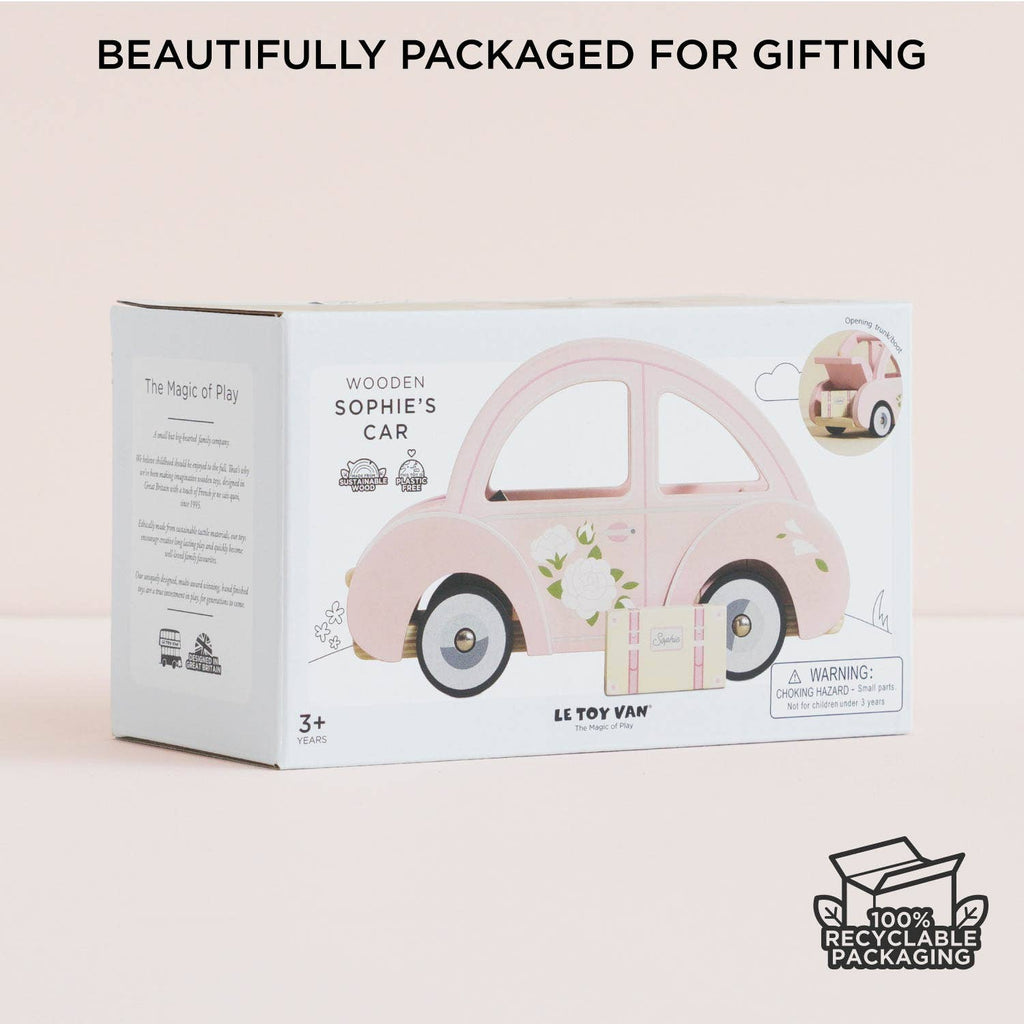 A box of "Sophie's Dolls House Toy Car," a pink wooden car with floral designs, sits on a pale surface. Above, text reads "Beautifully Packaged for Gifting." In the corner is a "100% Recyclable Packaging" icon.