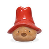 The Paddington Money Bank is a ceramic coin bank shaped like Paddington Bear’s head, with light brown fur, black eyes, a round nose, and a big red hat. His friendly face stands out against the simple white background.