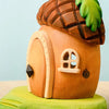 The Bumbu Handmade Wooden Acorn House is a charming toy shaped like an acorn, featuring a rounded door, tiny window, and roof leaf detail on a green leaf-shaped base—perfect as an enchanting fairy dwelling.