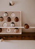 The My Little Lady Bug Wooden Puzzle, inspired by Montessori toys, features ladybug-shaped pieces in brown, white, and tan on a cream-colored background adorned with numbers and leaf designs. This charming puzzle encourages early math skills through playful hands-on learning.