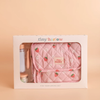 The Tiny Nurturers Set - Strawberry Picnic For Dolls comes in a box and includes a pink quilted doll nappy bag with strawberry and flower print, a toy bottle, spoon, and a magic baby doll cereal jar, all displayed against a beige background.