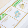 A corner of the Monopoly Bianco Edition gold foil-stamped game board featuring Pennsylvania and North Carolina Avenue properties, a Community Chest space with a treasure chest illustration, and a gold-colored thimble playing piece.