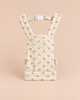 Quilted cream-colored Olli Ella Quilted Doll Carrier - Rainbow, featuring small rainbow patterns, adjustable straps, and a white plastic buckle, displayed upright on a beige background—perfectly sized as a charming doll carrier for imaginative play.