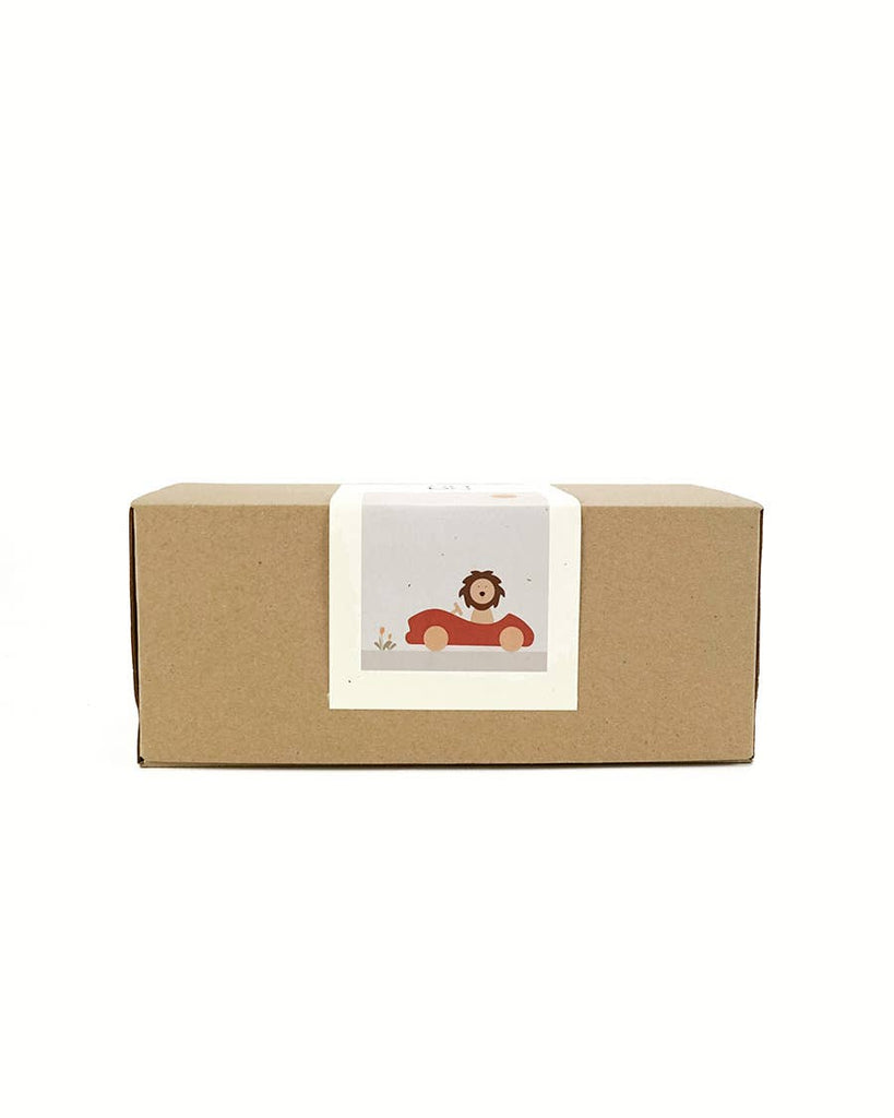 A plain brown rectangular box with a white label featuring an illustration of a lion driving a red car, inspiring imagination and open-ended play with the Sabo Concept First Journey.
