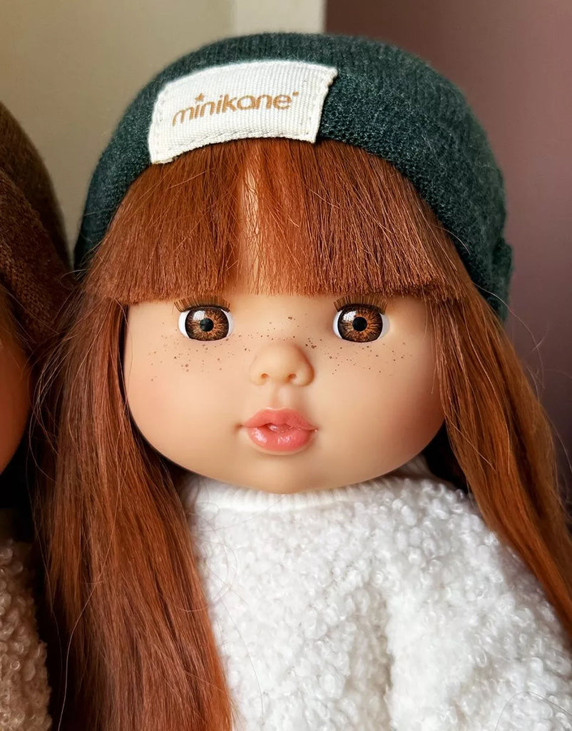 The Minikane Baby Doll (13") - Amber features long straight auburn hair, brown eyes, and freckles. This adorable anatomically correct doll is made in Spain. Clothing sold separately.