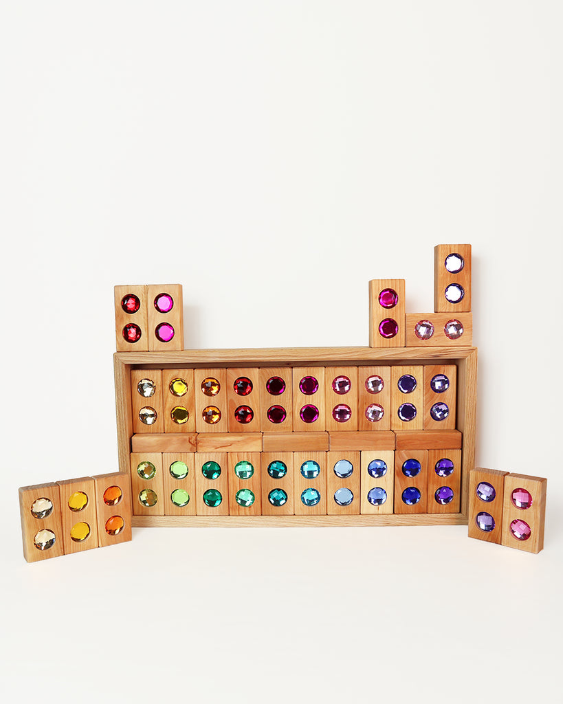 Bauspiel Large Gem Blocks, 45-Piece Set, featuring wooden blocks inset with colorful, faceted acrylic gems, arranged in a large rectangle with smaller stacks placed on the sides and top.