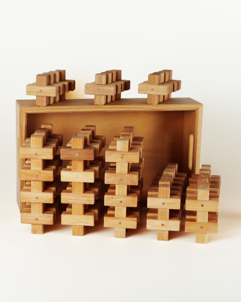 A set of 36 interlocking Bauspiel Plus Building Blocks arranged in a shallow wooden storage tray.