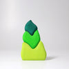 Grimm's Tower Leaves Building Blocks features three abstract, irregularly shaped handpainted lime wood blocks in different shades of green, stacked together against a plain white background.