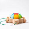 A Grimm's Rainbow Turtle Pull-Toy and Building Blocks featuring a small car with four wheels and a multicolored shell on top. Made from non-toxic materials, the car is attached to a green string for easy pulling. The shell has segments in blue, yellow, green, and red. Ideal for developing fine motor skills on a plain white background.