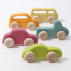 Grimm’s Wooden Cars Slimline, available in orange, yellow, pink, blue, and green, are arranged on a white surface. Each car features simple shapes, smooth natural wood wheels, and a safe finish with natural oils—perfect toddler toys for creative play (ships in 2-3 weeks).