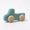 Grimm’s Wooden Cars Slimline—a simple wooden toy truck painted blue with natural, unpainted wooden wheels and a smooth natural oils finish—photographed on a white background, makes an ideal addition to any collection of classic wooden toy cars or toddler toys.