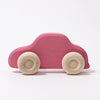 Grimm’s Wooden Cars Slimline is shown against a plain white background—an ideal choice for those seeking charming and safe toddler toys, featuring a simple pink wooden body with natural wood wheels and a smooth natural oils finish.