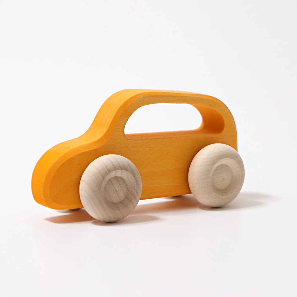 A Grimm’s Wooden Cars Slimline, finished with smooth natural oils and featuring yellow painted wood with natural wood wheels, is displayed on a white background—making it a perfect choice for toddler toys.