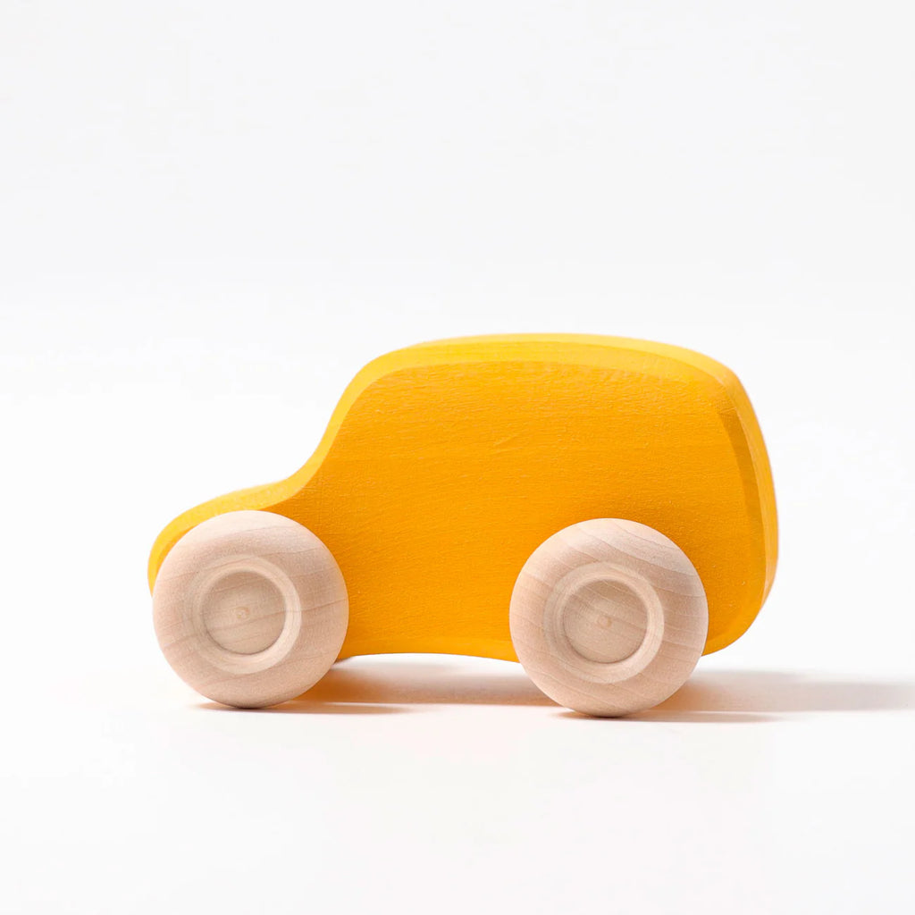 A simple yellow Grimm's Colored Wooden Car with round, natural wood wheels is displayed on a white background—perfect for anyone seeking non-toxic toys.
