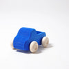 A Grimm's Small Blue Truck, a simple non-toxic wooden toy truck painted blue with natural wood-colored wheels, photographed on a plain white background.