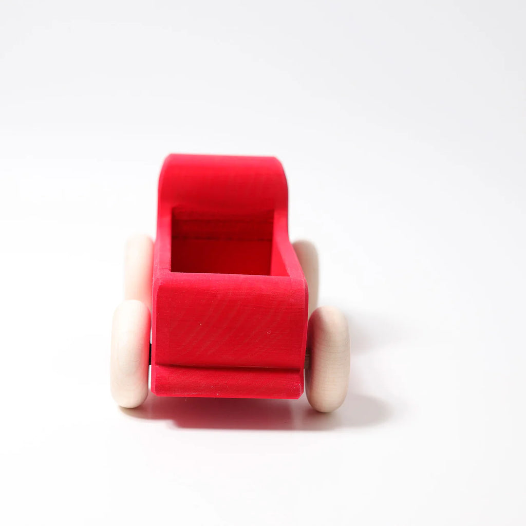 Grimm's Large Red Truck, a handcrafted wooden toy made in Germany with non-toxic materials, features white wheels and is displayed front-facing on a plain white background.