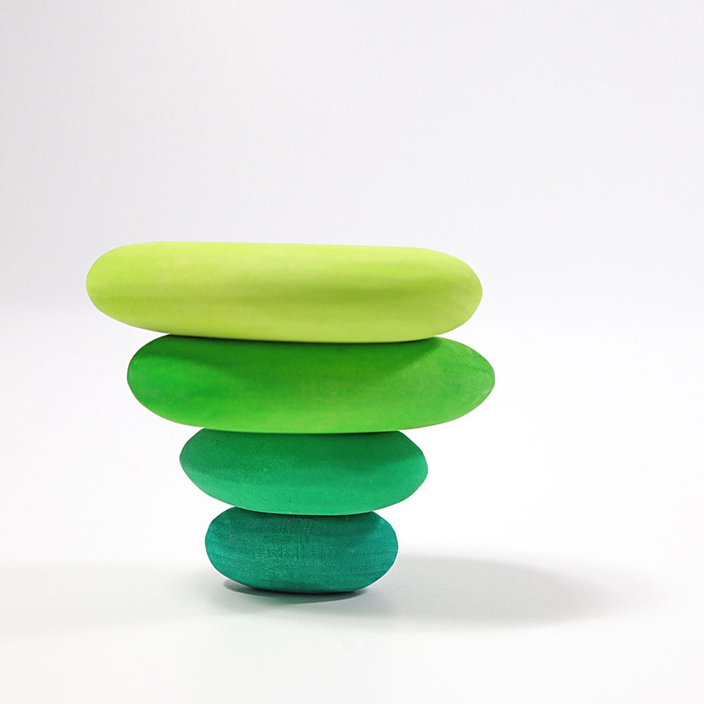 A stack of four smooth, organic stone shapes is balanced against a plain white background. The Moss Pebbles Stacker stones are arranged from largest at the bottom to smallest at the top and are colored in varying shades of green, transitioning from dark to light.