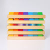 Grimm's Shapes and Colors Set features multicolored geometric building blocks in four wooden trays, each displaying a rainbow gradient from red to green—perfect for developing fine motor skills.