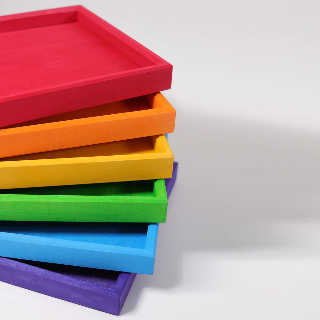 Grimm's Rainbow Frames (coming soon): A set of six rectangular wooden trays in red, orange, yellow, green, blue, and purple—ideal for organizing kids' workspaces—displayed diagonally on a white surface.