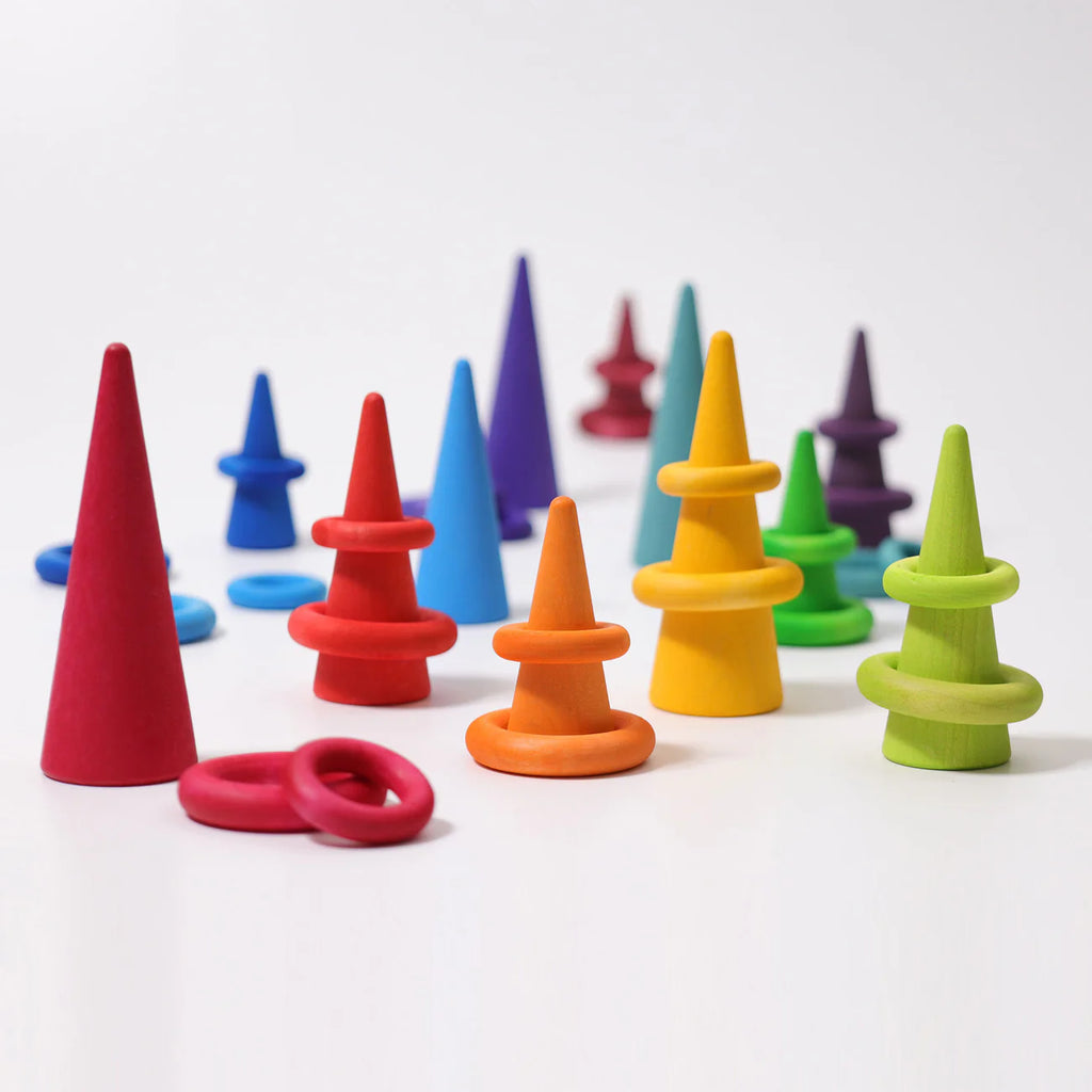 Grimm's Building Rings - Rainbow are colorful wooden stacking toys with removable rings, arranged in vibrant red, orange, yellow, green, blue, and purple clusters—ideal for developing fine motor skills.
