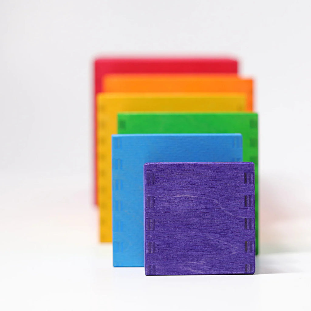 Grimm's Large Set of Boxes - Rainbow features five non-toxic wooden boxes in purple, blue, green, yellow, and red standing upright in a row on a white background, each one slightly overlapping for a delightful rainbow display.