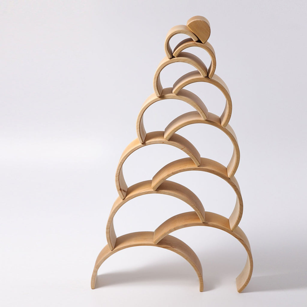 A Grimm's Large Natural Rainbow Stacker featuring an abstract, tree-like design is constructed of stacked, arching curves made from alder-wood. Each layer of arches decreases in size and balances atop the one below, forming a vertical, pyramid-like structure against a plain white background.