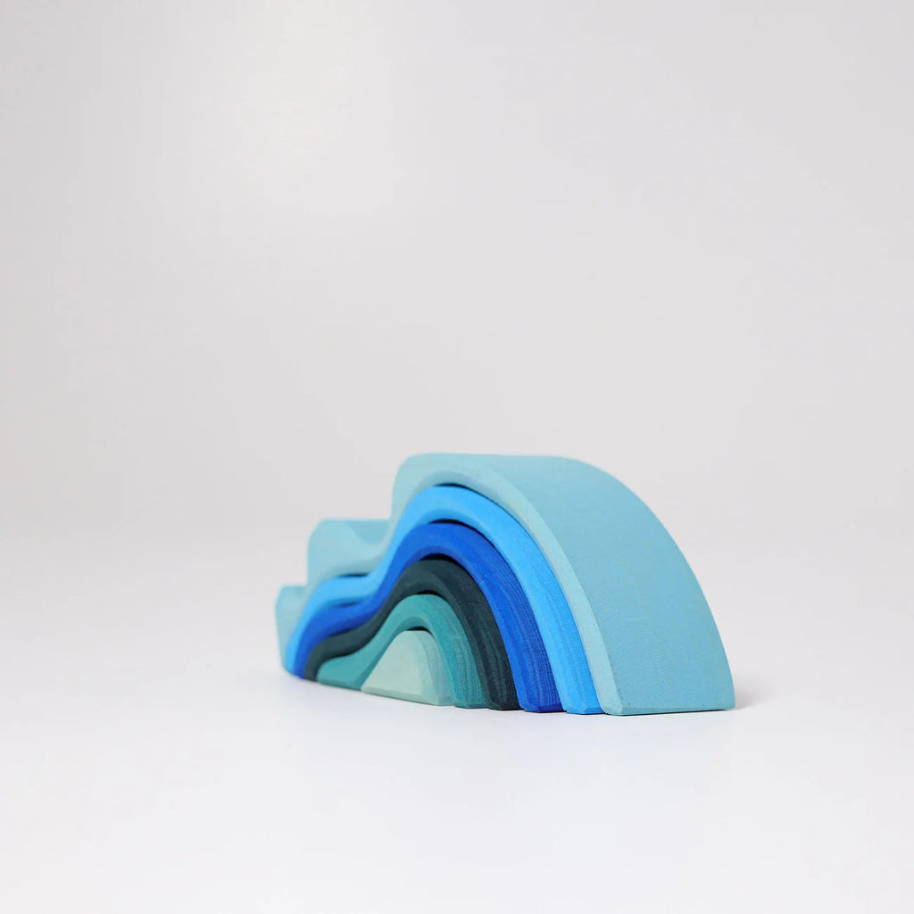 Grimm's Ocean Waves, Small features five blue wooden arches in descending sizes, beautifully arranged on a white surface and perfect as a stacking toy for toddlers.