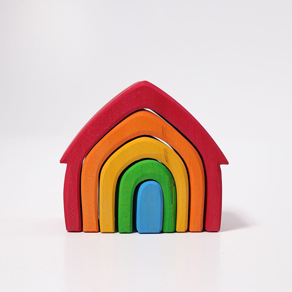 A Grimm's Colorful House Stacker made of nested, rainbow-colored arches is shown against a plain white background. The non-toxic arches are red, orange, yellow, green, and the innermost arch is blue, resembling a stylized door—perfect for toddlers.