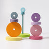 The image shows a vibrant Pastel Stacking Tower featuring circular disks of various sizes and colors, including orange, pink, yellow, green, purple, and blue. These toys are excellent for developing fine motor skills and eye-hand coordination as the disks are stacked on rods with sturdy bases in different arrangements.