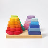 Grimm’s Stacking Game Shapes featuring two wooden towers on a base: one with rainbow flower petals and the other with blue and purple square blocks to help develop fine motor skills.