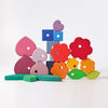Grimm’s Stacking Game Shapes: a stack of colorful, geometric wooden hearts, flowers, squares, and leaves used as a stacking toy.