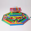 A colorful, intricate children's building toy made of interlocking, rectangular wooden blocks is displayed on a white background. The blocks are arranged in various layers and orientations, creating a vibrant, geometric design with red, pink, yellow, blue, green, and purple pieces that encourage fine motor skills development. Grimm's Leonardo da Vinci Building Sticks are perfect for inspiring creativity and educational play among young children.