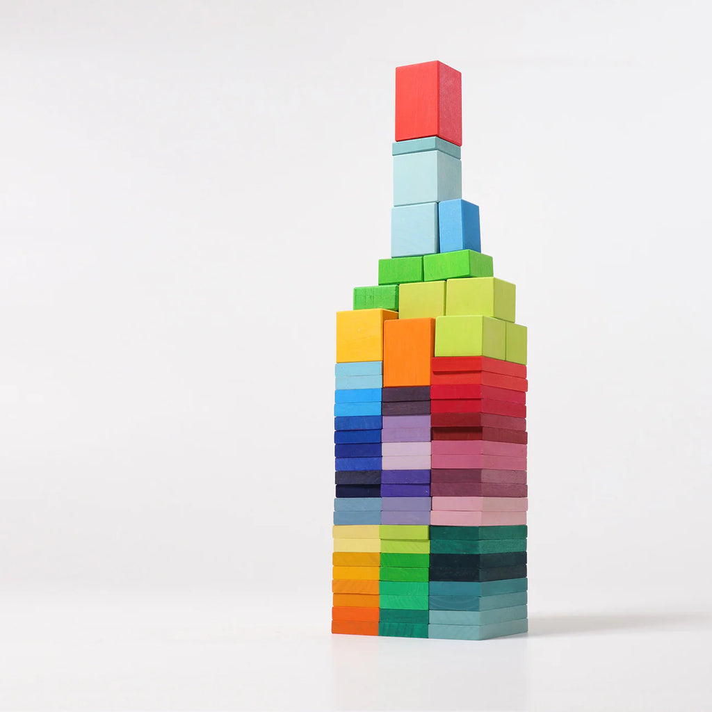 A tall tower built with Grimm's Color Charts-Rally blocks is stacked neatly against a white background. The gradient colors inspire creative play while boosting children's fine motor skills as they build and explore.