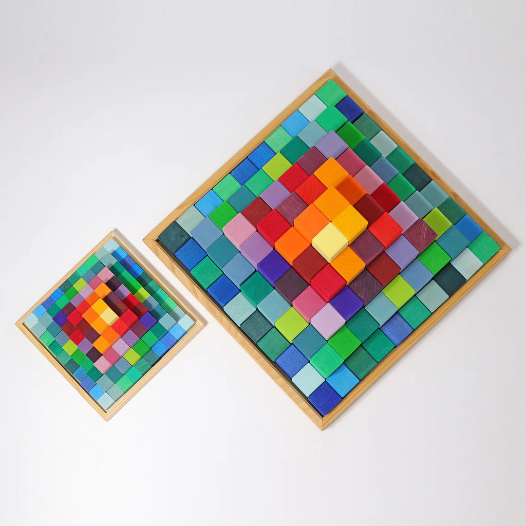 Two square wooden boards featuring colorful, raised square tiles in a symmetrical gradient from yellow and red at the center to greens and blues at the edges, inspired by Grimm's Stepped Pyramid Block Set - Small, handcrafted in Germany.