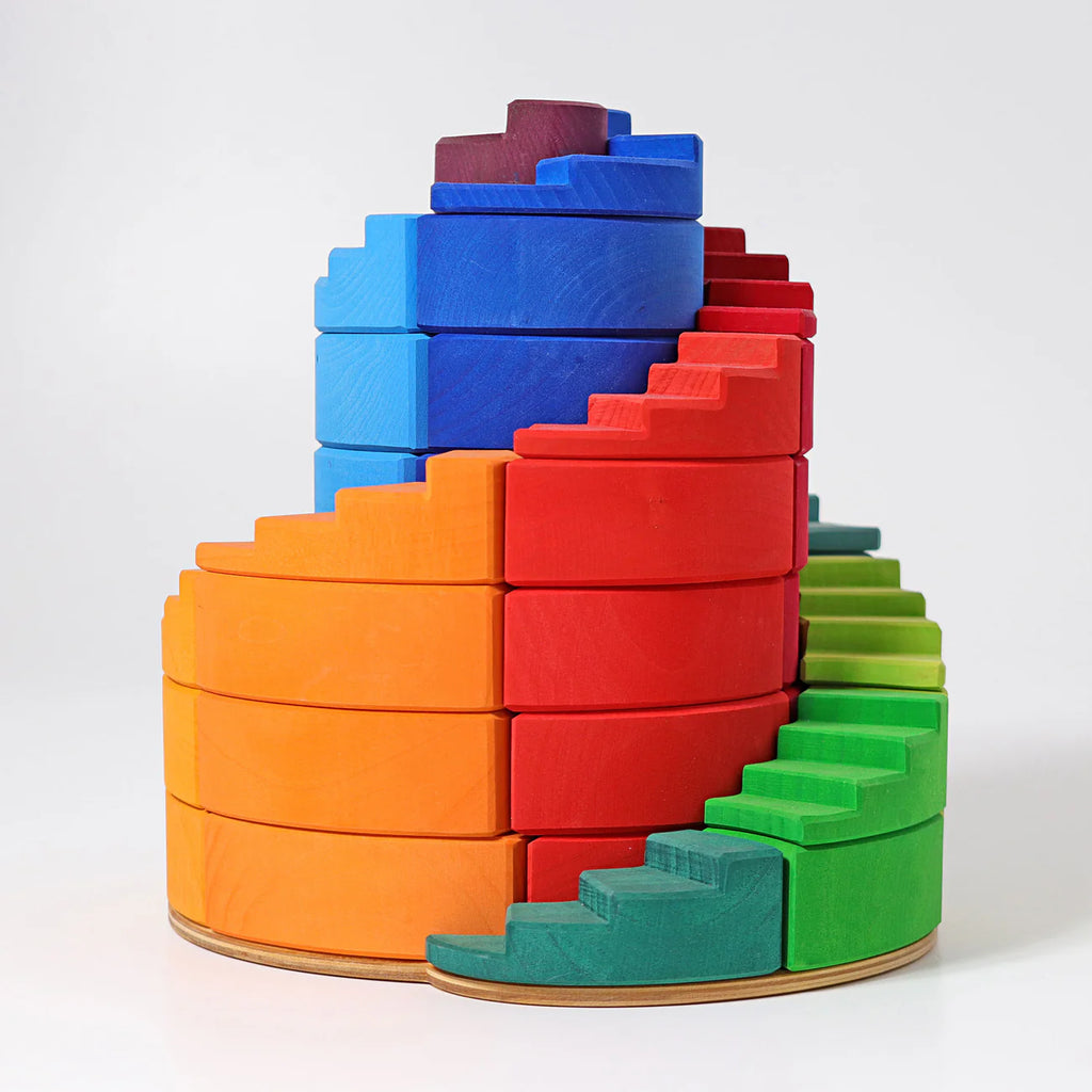 Grimm's Counterrotating Stepped Spiral is a colorful wooden stacker with green, yellow, orange, red, blue, and purple segments that help develop fine motor skills as children arrange them in a vibrant gradient.