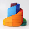 Grimm's Counterrotating Stepped Spiral is a colorful wooden stacking toy with curved, spiral pieces in yellow, orange, red, blue, green, and purple on a round base.