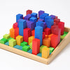 Grimm's Stepped Counting Blocks - Small (coming soon): A wooden tray with non-toxic blocks in green, yellow, orange, red, blue, and purple, arranged by height in a grid that creates a vibrant cityscape effect.