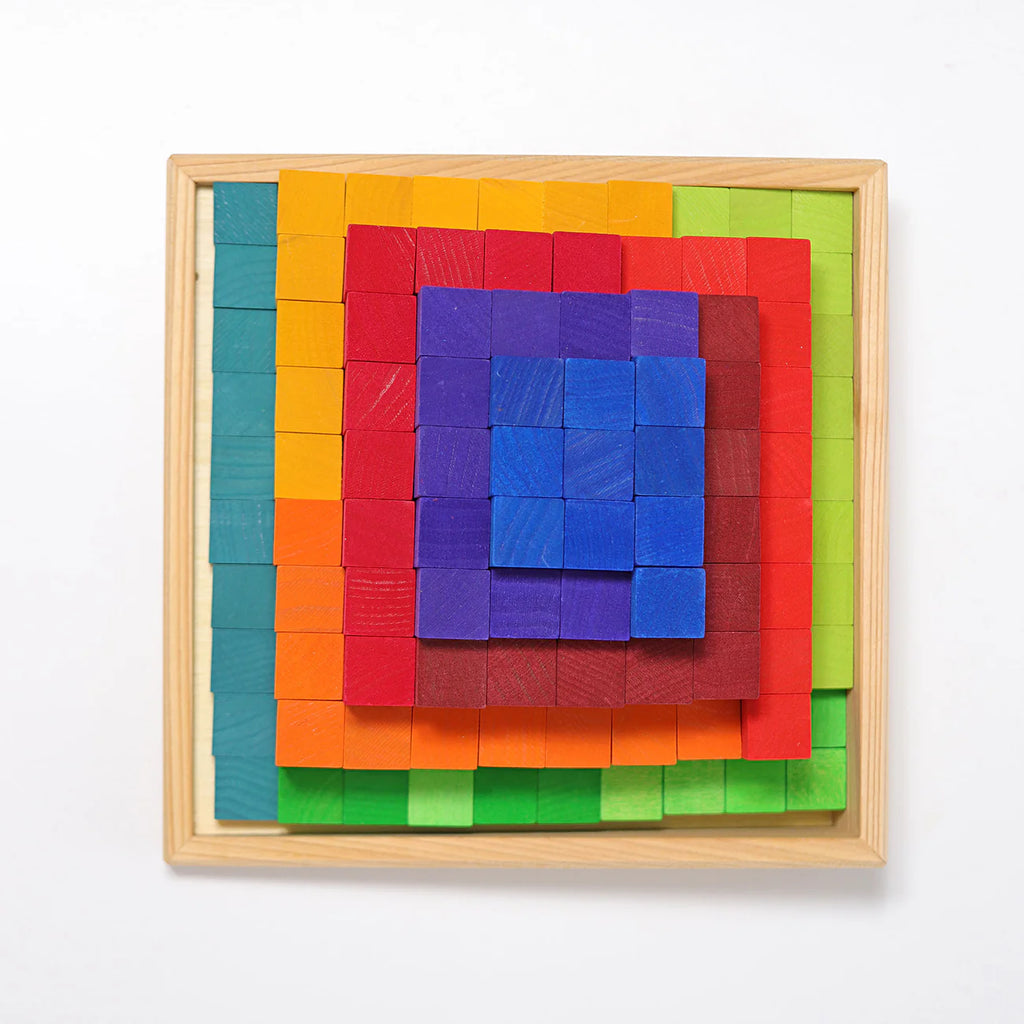 Grimm's Stepped Counting Blocks - Small (coming soon) is a non-toxic wooden puzzle featuring small rainbow blocks in green, teal, orange, yellow, red, purple, and blue layers inside a square frame, set against a white background.